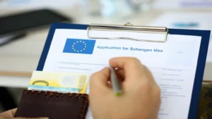Understanding The Reasons Behind Schengen Visa Refusal For Nigerians 1 Male hand hold silver pen with passport